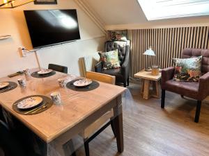 a living room with a table and chairs and a television at B&B Tina in Sneek