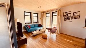 ein Wohnzimmer mit einem blauen Sofa und einem Sessel in der Unterkunft WegeLager in Burgjoß