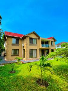 a house with a palm tree in front of it at Bliss House in Dar es Salaam