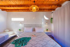 a bedroom with a bed and a chandelier at SantoriniNY in Perissa