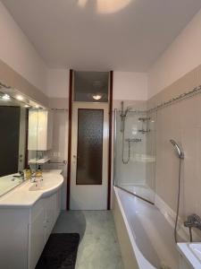 a bathroom with a tub and a sink and a shower at La finestra sul trenino in Tirano +11 photos