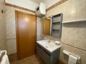 a bathroom with a sink and a mirror at L'Attico di Romolo a 150 mt dal mare in San Pietro in Bevagna +23 photos