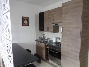 a kitchen with wooden cabinets and a black counter top at Locazione Turistica Gloria in Fiumicino Airport