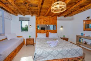 a bedroom with two beds and a chandelier at SantoriniNY in Perissa