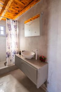 a bathroom with a sink and a mirror at SantoriniNY in Perissa