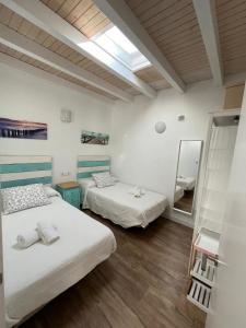 una habitación con dos camas y un espejo en Villa de la luz, en Tarifa