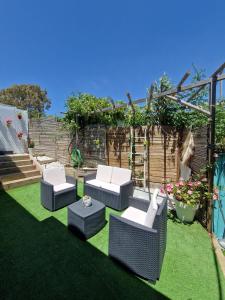 Un jardín con sillas y una pérgola. en Villa de la luz, en Tarifa
