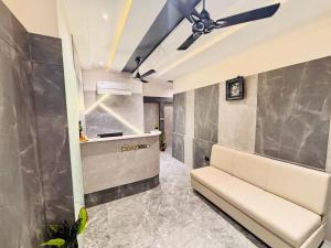 a living room with a couch and a ceiling fan at Hotel Sparsh Inn in Ahmedabad