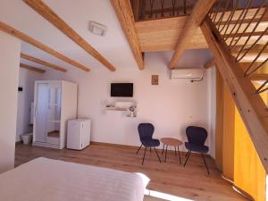 a bedroom with two chairs and a table and a bed at Complex Turistic Padurea Mare in Bălţăteşti