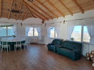 a living room with a couch and a table at Complex Turistic Padurea Mare in Bălţăteşti +16 photos