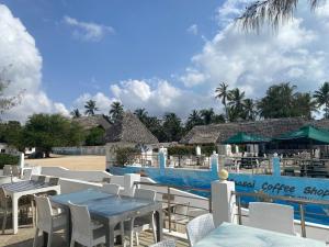 a restaurant with a table and chairs next to a pool at The Beach House by Maasai in Mombasa
