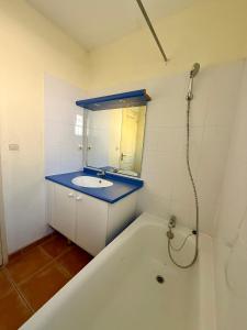 a bathroom with a tub and a sink and a mirror at Maison dans village vacances avec piscine in Gaujac