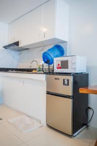 uma cozinha com um balcão com pia e micro-ondas em Burnham Hill 2BR Condo em Baguio
