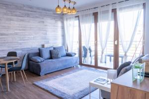 a living room with a blue couch and a table at MWellness Apartment in Siófok