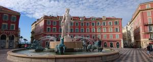 a fountain with a statue of a man on horses at Hotel De La Mer in Nice