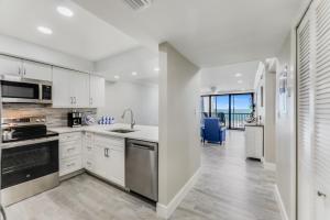 サニベルにあるSundial A306の白いキャビネットとステンレス製の電化製品を備えたキッチン +7枚の写真