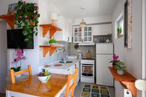 Una cocina con gabinetes blancos y una mesa de madera. en Tesla FlyInn, en Belgrado