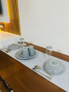 a table with two plates and glasses on it at MyHome Condo with Balcony in Iloilo City