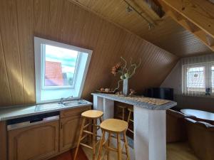 - une cuisine avec un comptoir, un évier et des tabourets dans l'établissement Ruhiges Stadtdomizil - Wohnkomfort in der Vier-Tore-Stadt, à Neubrandenbourg