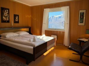 a bedroom with a large bed and a window at Svingen Guesthouse - Panoramic Fjord Views in Flåm in Flåm