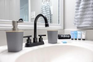 a bathroom sink with a faucet and toothbrushes at Cozy Family Home Downtown-KingBed-Free Parking-Central in Atlanta +38 photos
