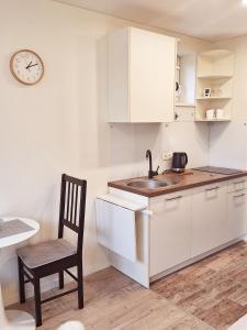 a kitchen with a sink and a chair and a clock at Santauta in Juodkrantė +13 photos