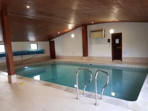 a large swimming pool in a large room with at Acorns in Plaitford