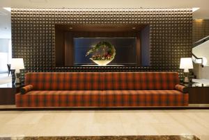 a couch in a lobby with a wreath on a wall at Matsue Excel Hotel Tokyu in Matsue