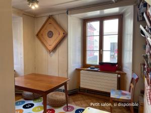 a small room with a table and a window at Maison La Coquille in La Chaux-de-Fonds