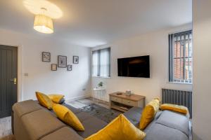 a living room with a couch with yellow pillows at Crown Street Apartments in Wellington
