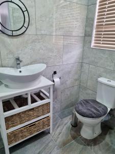 a bathroom with a sink and a toilet at Catch and Relax St Helena Bay in West Point
