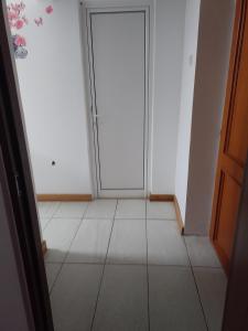 une chambre vide avec une porte et du carrelage dans l'établissement Garsoniera, à Ocniţa