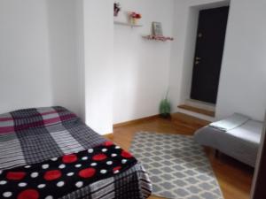 a small room with a bed and a rug at Garsoniera in Ocniţa