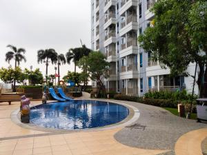 a swimming pool with a slide in front of a building at Comfy and Modern Wonderful 2BR Apartment at Tanglin Supermall Mansion By Travelio in Surabaya