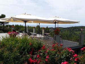 a patio with tables and umbrellas and flowers at Arpaderba B&B in Livorno