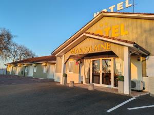 a store with a sign on the side of a building at Hotel Marjolaine in Roullet