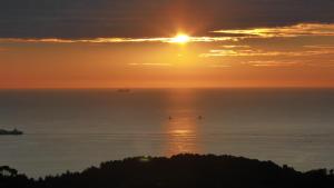 a sunset over the ocean with boats in the water at Arpaderba B&B in Livorno