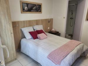 a bedroom with a bed with two pillows on it at Studio des Thermes in Amnéville