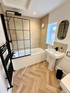 a bathroom with a tub and a sink at Waterside House - Luxury Home near Alton Towers & Trentham - Free Parking & Garden in Stoke on Trent +31 photos