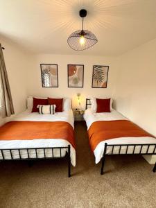 two beds sitting in a room with at Waterside House - Luxury Home near Alton Towers & Trentham - Free Parking & Garden in Stoke on Trent