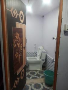 a bathroom with a toilet and a door to at Ishwar Place Rooms and Cafe Gokarna in Gokarna