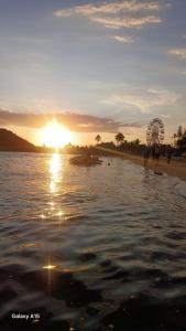 a ferris wheel on a beach with the sun setting at Casa na praia com 2 quartos in Itanhaém +9 photos