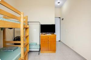 een slaapkamer met een stapelbed en een bureau met een televisie bij Pousada da Vila Araçariguama-SP in Araçariguama