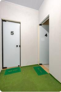 een kamer met een witte deur en een groen tapijt bij Pousada da Vila Araçariguama-SP in Araçariguama +2 foto's