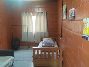 een kleine kamer met een wieg en een raam bij Pousada da Vila Araçariguama-SP in Araçariguama