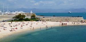 a group of people on a beach near the water at Crew Lighthouse in Antibes