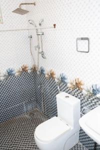 a bathroom with a white toilet and a shower at Kanapathiy Rest House in Trincomalee +15 photos