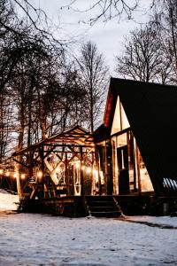 a small building with lights on it in the snow at Koka namiņš "Pasaka" in Vecumnieki