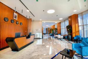 a lobby of a hospital with blue chairs and tables at ADAY Hotel Casablanca in Casablanca