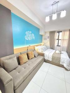 a living room with a couch and a bed at Luxurious condo with City View in Cebu City